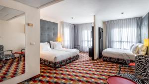a hotel room with two beds and chairs at Jacob Harmony in Jerusalem