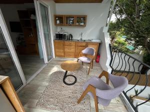 a kitchen with a table and chairs on a balcony at Lakaz feuillaze in Port Mathurin