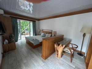 a bedroom with a bed and a desk and a window at Lakaz feuillaze in Port Mathurin