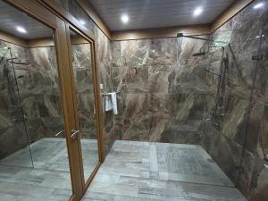 a bathroom with a shower with a glass door at Lakaz feuillaze in Port Mathurin