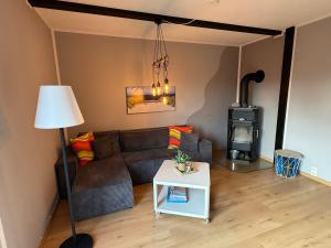 a living room with a couch and a wood stove at Strandgut- unsere Große in Dranske