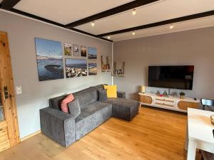 a living room with a couch and a flat screen tv at Strandgut- unsere Große in Dranske