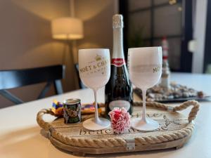 a tray with two wine glasses and a bottle of wine at Strandgut- unsere Große in Dranske