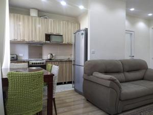 a living room with a couch and a kitchen at AURA on Erkindik boulevard in Bishkek