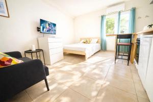 a living room with a couch and a bed at Les hébergements Rousseau in Oyonnax