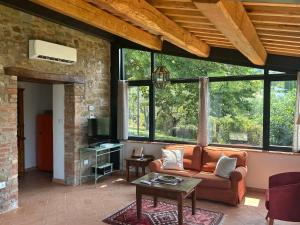 a living room with a couch and a tv at Fontanaro Farm and Culinary School in Paciano