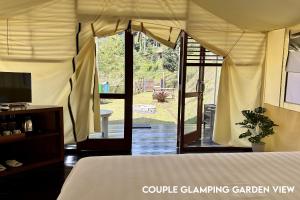 a bedroom with a bed and a sliding glass door at Alinson Sunset Hill in Bogor