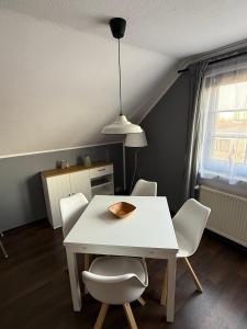 a dining room with a white table and chairs at Strandgut- unsere Kleine in Dranske