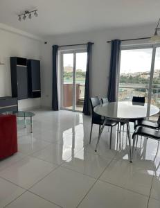 a dining room with a table and chairs and a window at Park Lane Experience Apartments in Il-Gżira