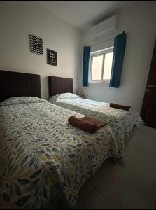 a bedroom with two beds and a window at Park Lane Experience Apartments in Il-Gżira