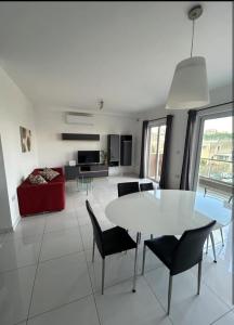 a living room with a white table and chairs at Park Lane Experience Apartments in Il-Gżira +1 photo