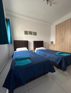 two beds in a room with blue comforters at Park Lane Experience Apartments in Il-Gżira