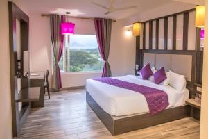 a bedroom with a large bed and a window at Regency Palani by GRT Hotels in Palni +34 photos