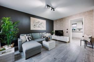 a living room with a couch and a tv at SleepLuxury ApartHOUSE in Glasgow
