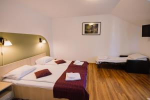 ein Hotelzimmer mit zwei Betten, auf denen Handtücher liegen in der Unterkunft Vila Rigo Sovata in Sovata