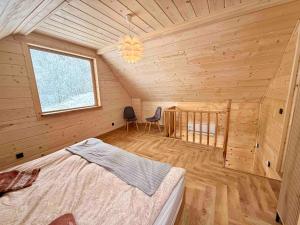 a bedroom with a bed in a wooden cabin at Slow Mountains in Wola Piskulina