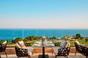 a dining table and chairs on a patio with a view at Zeus Eleva Ajul in Agia Paraskevi