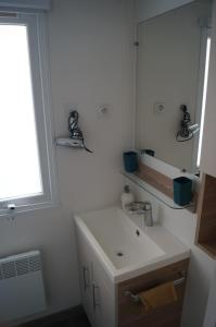 a bathroom with a sink and a mirror at Mobile home 8 personnes in Sérignan