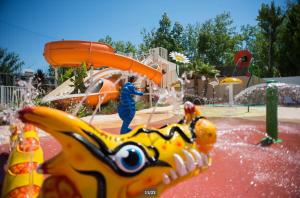 a child on a water slide at a water park at Mobile home 8 personnes in Sérignan