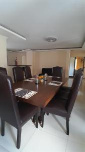 a dining room table with black chairs around it at The Rock BnB in Francistown +27 photos
