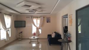 a living room with a couch and a tv at The Rock BnB in Francistown