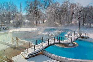 a bridge over a hot spring in a park in the snow at Ferienwohnungen Tweraser in Bad Birnbach