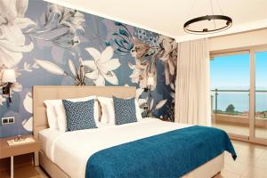 a bedroom with a bed with a blue and white floral wallpaper at Zeus Eleva Ajul in Agia Paraskevi +153 photos