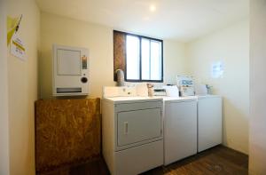 a laundry room with a washer and dryer and a window at Traveller Inn - Rail Haus in Taitung City +34 photos