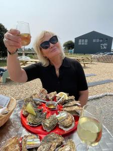 a woman sitting at a table with a plate of oysters at Constance de Bretagne B&B in Batz-sur-Mer +27 photos