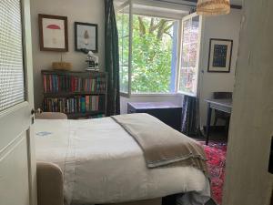 a bedroom with a bed and a book shelf and a window at La Maison dans la forêt in Vabre
