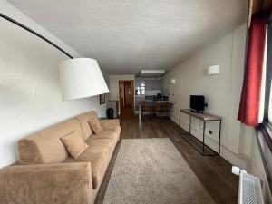 a living room with a couch and a television at Résidence Le Portillo in Val Thorens +21 photos