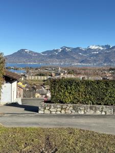 a person sitting on a sidewalk next to a stone wall at Torrent House in Bouveret