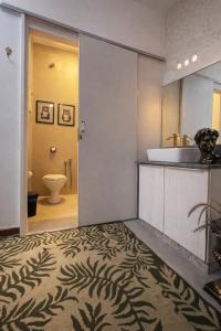 a bathroom with a sink and a toilet at Studio Romã térreo com cozinha in Curitiba