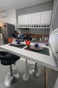 a kitchen with a counter with red wine glasses on it at Studio Romã térreo com cozinha in Curitiba +12 photos