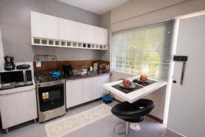 a kitchen with a counter and a stool in it at Studio Romã térreo com cozinha in Curitiba