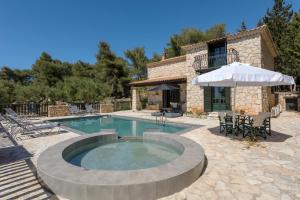 a pool with a table and chairs and an umbrella at Villa Lida Aresti by Sealand Villas in Agios Leon