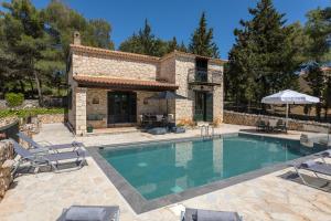 a swimming pool in front of a house at Villa Lida Aresti by Sealand Villas in Agios Leon