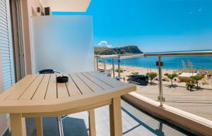 ein Holztisch auf einem Balkon mit Blick auf den Strand in der Unterkunft Kleanthi`s Hotel in Himarë