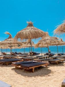 eine Gruppe von Stühlen und Sonnenschirmen an einem Strand in der Unterkunft Kleanthi`s Hotel in Himarë