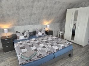 a bedroom with a large bed and a mirror at Ferienwohnung, Urlaub im Frankenwald in Konradsreuth