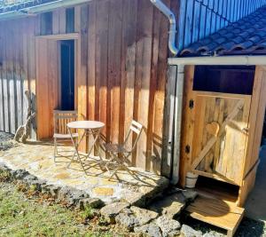 a small patio with a table and chairs next to a building at Le Rucher d'Ange in Quillan