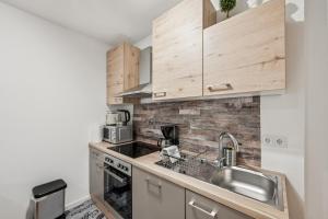 a kitchen with wooden cabinets and a sink at Ramoni Apartments - Bad Wildbad in Bad Wildbad