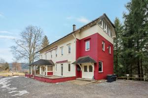 a red and white building in a parking lot at Ramoni Apartments - Bad Wildbad in Bad Wildbad