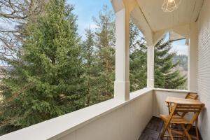 a porch with two chairs looking out at trees at Ramoni Apartments - Bad Wildbad in Bad Wildbad