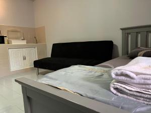 ein Schlafzimmer mit einem Bett und einer Couch in der Unterkunft Popular Condo by Jintana in Pak Kret + 55 Fotos