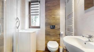 a white bathroom with a toilet and a sink at Apartament Fibra Latte in Rybnik +18 photos