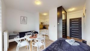 a bedroom with a bed and a table and chairs at Apartament Fibra Latte in Rybnik