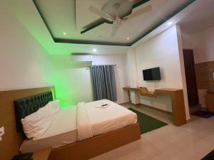 a bedroom with a bed and a ceiling fan at Hotel Glitter in Guwahati
