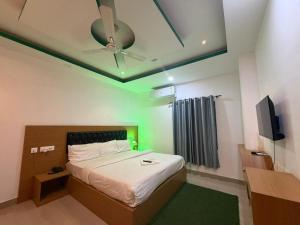 a bedroom with a bed with a ceiling fan and a television at Hotel Glitter in Guwahati