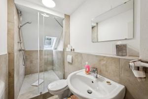 a bathroom with a sink and a toilet and a shower at Ramoni Apartments - Bad Wildbad in Bad Wildbad +48 photos